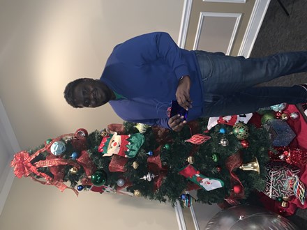 Man in blue shirt in front of Christmas tree